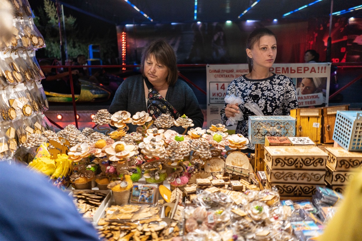 дві жінки продають вироби з дерева