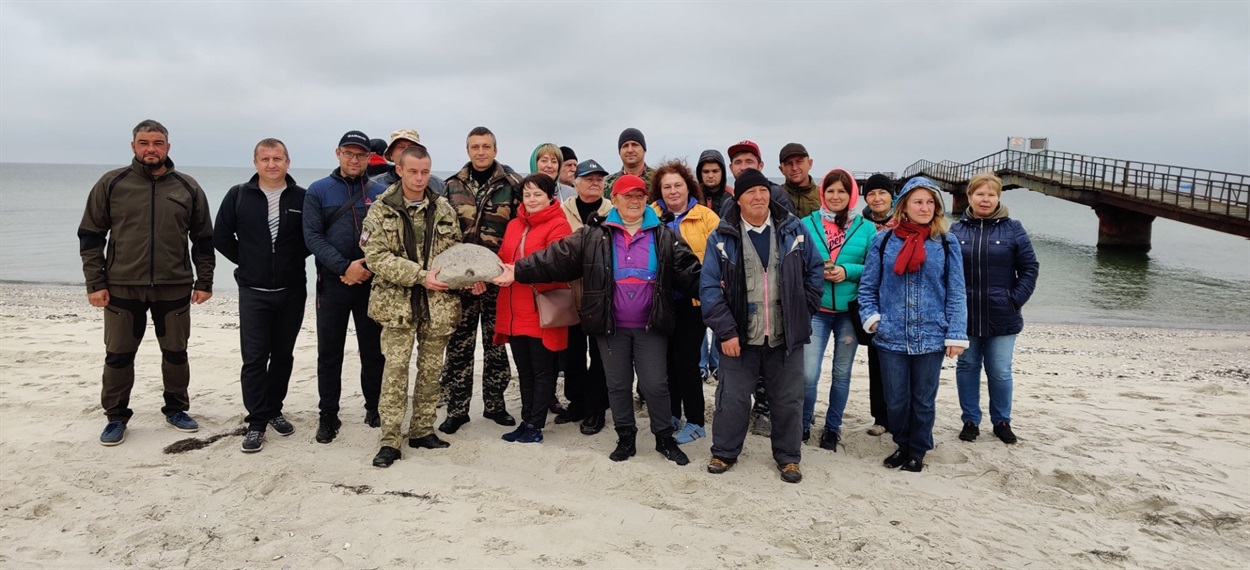 люди позують з основою колони ольвійського періоду