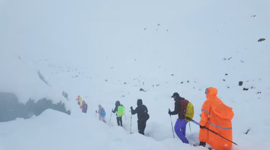 Туристи покидають табір після того як сильний снігопад і злива випали в Гімалаях, Китай, 5 жовтня 2025