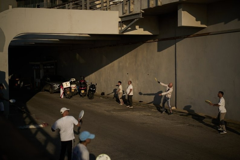 Люди грають у падлбол біля підземного паркінгу, який використовується як бомбосховище, неподалік від пляжу в Тель-Авіві, Ізраїль. 2 березня 2026